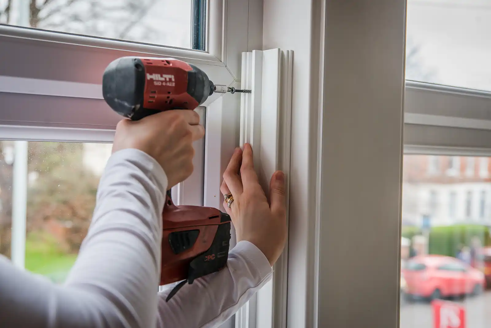 Close up of drilling DIY shutters into a window frame