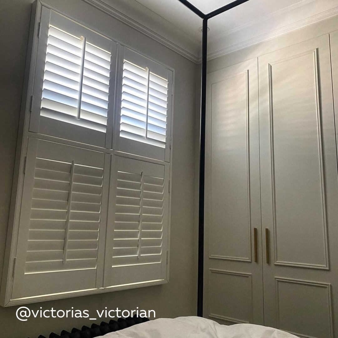White Tier on Tier Shutters in a modern bedroom with black four poster bed