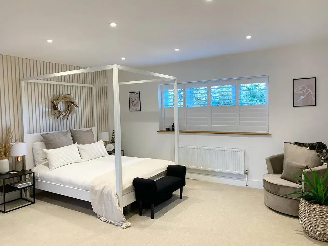 White Full Height Shutters with wide panels in a modern bedroom with white four poster bed
