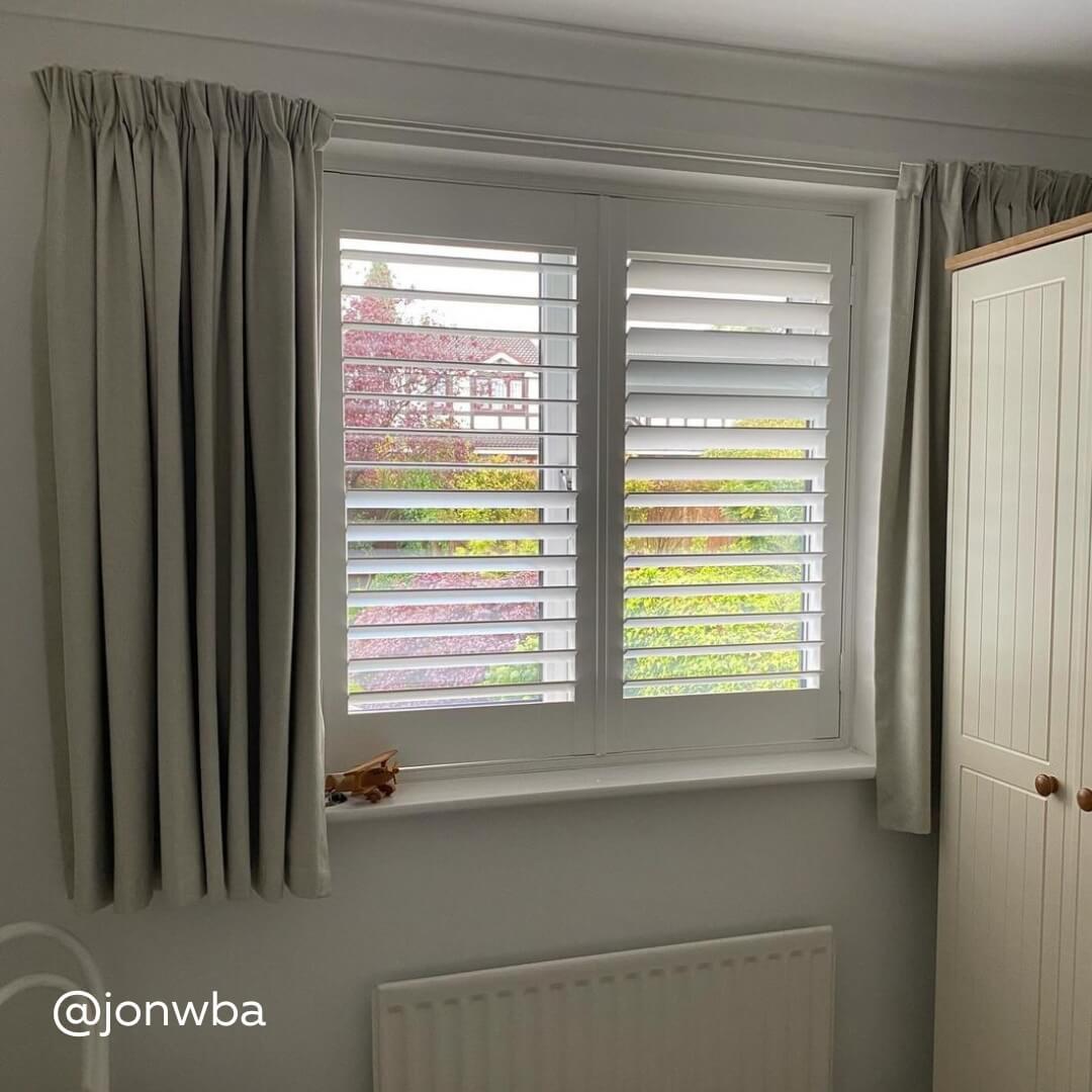 White Full Height Shutters in a bedroom with curtains